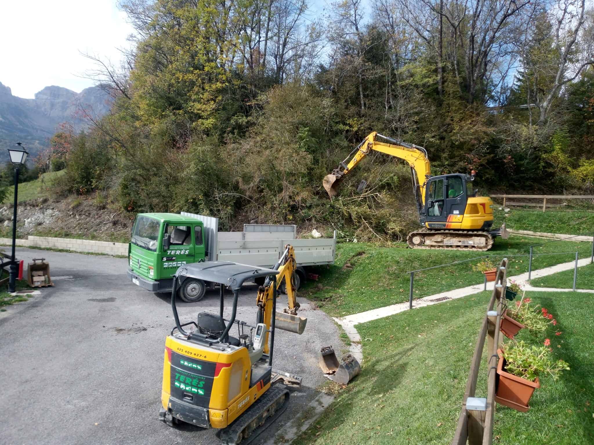 Maquinaria de excavación trabajando en jardines y paisajismo, servicios de obra civil y mantenimiento en Terés, construcción y limpieza de terrenos, trabajos con mini excavadoras y maquinaria pesada.