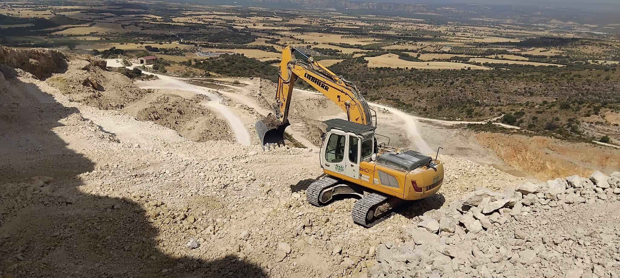 Maquinaria pesada excavadora trabajando en construcción de caminos en terrenos rurales en Trabajos y Servicios Terés.