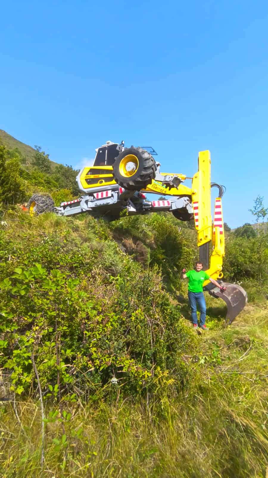 Cargadora forestal trabajando en terrenos escarpados, realizando trabajos de tala y rehabilitación en áreas naturales. Servicios profesionales de maquinaria pesada en naturaleza y medioambiente.