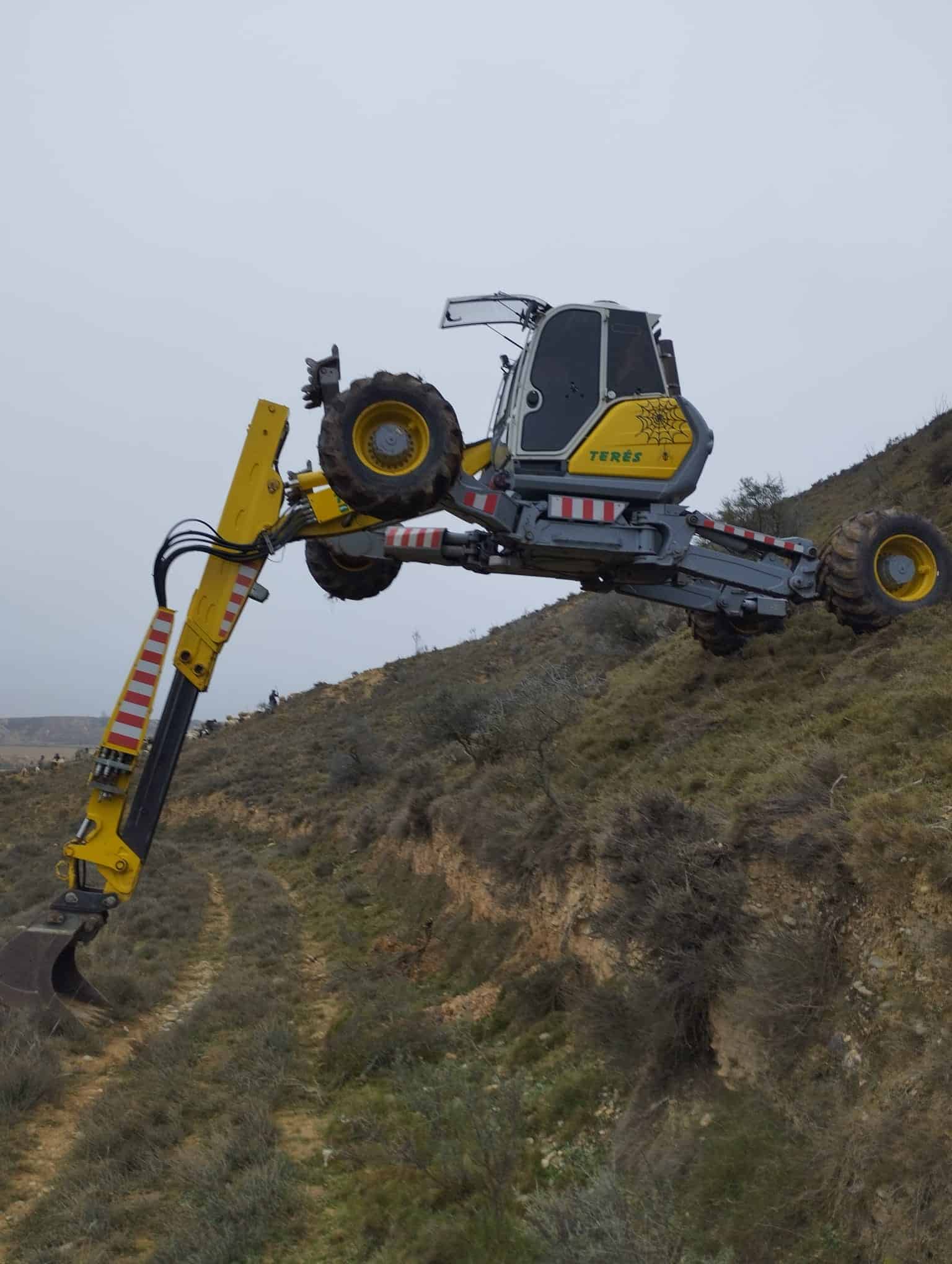 Maquinaria de excavación y trabajos en terrenos montañosos con equipo de la empresa Terés, especializada en obras y servicios de construcción y mantenimiento.