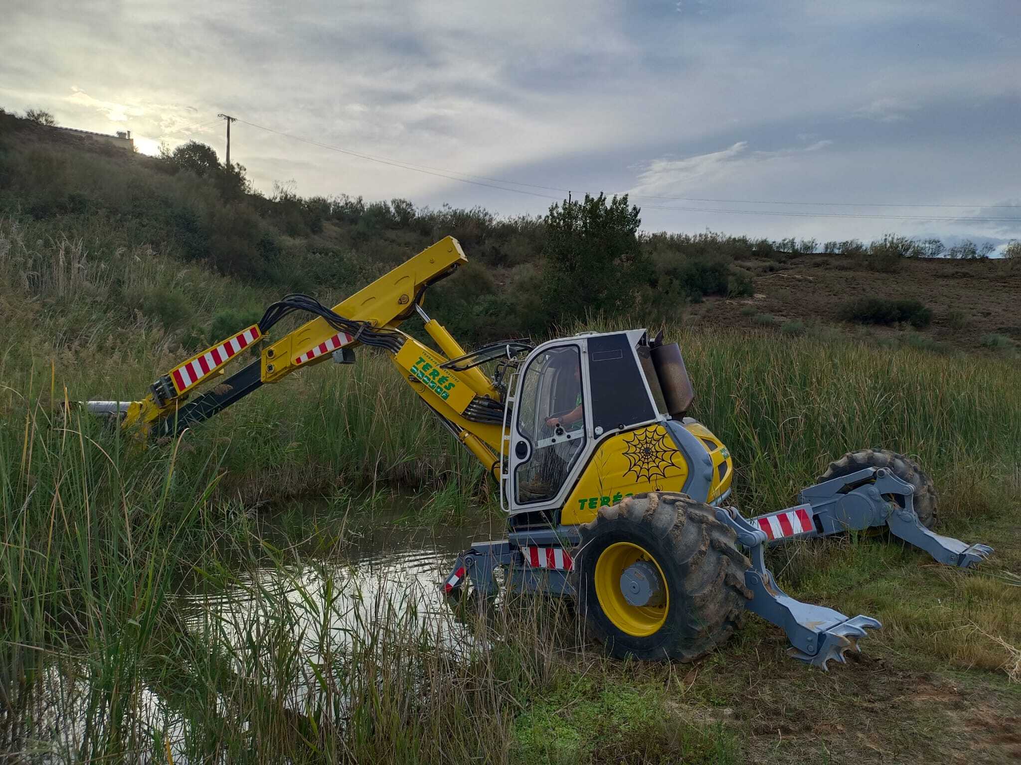 Alt: Maquinaria de obra terrestre en un entorno natural, utilizada para trabajos en terrenos húmedos y zonas de difícil acceso, destacando la innovación en servicios de construcción y excavación.