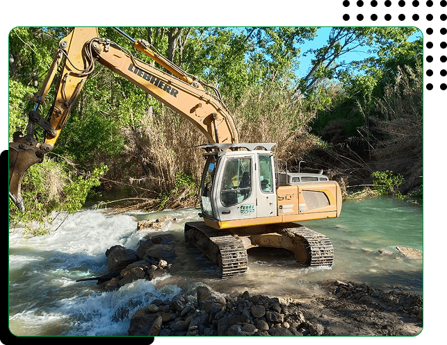 Excavadora trabajando en río para trabajos de construcción y mantenimiento en áreas naturales.