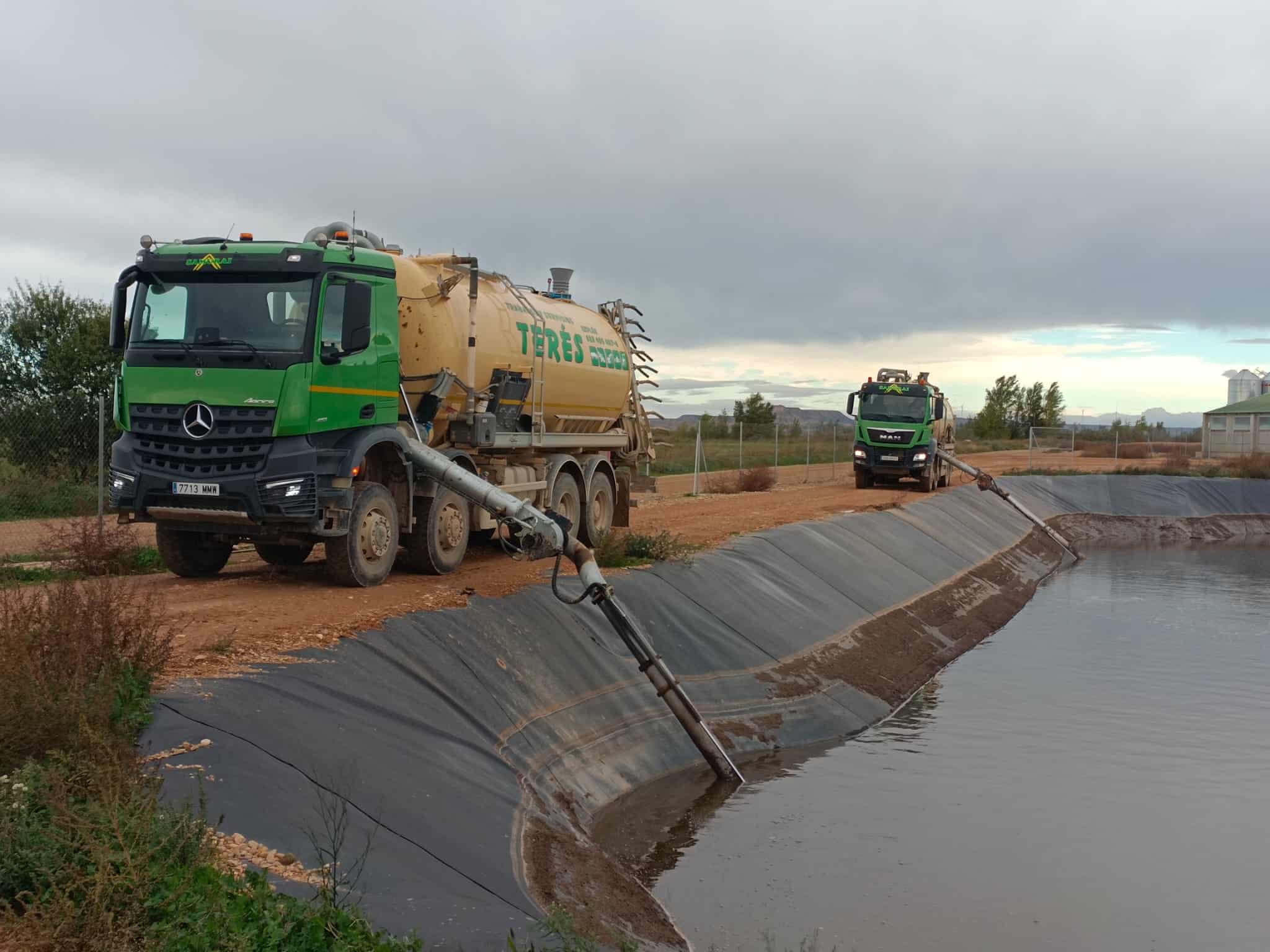Maquinaria de trabajos en obras hidráulicas vertiendo agua en un estanque, servicios de reparación y mantenimiento de infraestructuras, empresa de trabajos y servicios Terés en acción.
