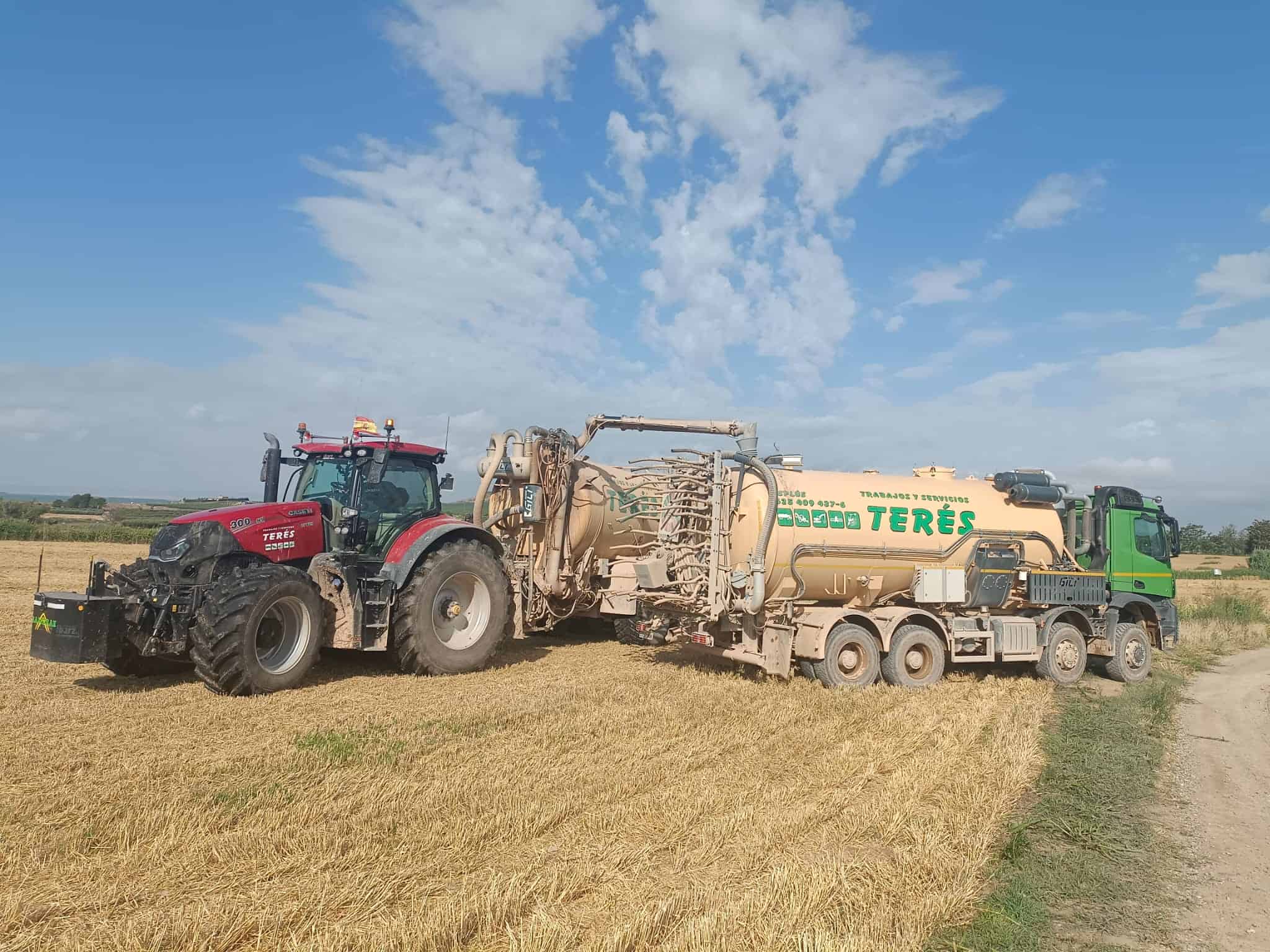 Camión de tractor y camión con servicios de trabajo agrícola en un campo de trigo en un día soleado.